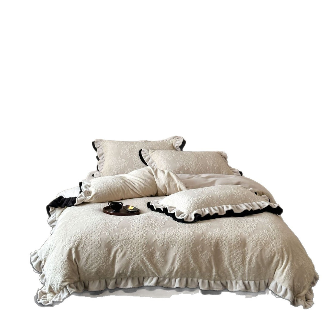 Quilted bedding set with floral embossing and ruffled frills