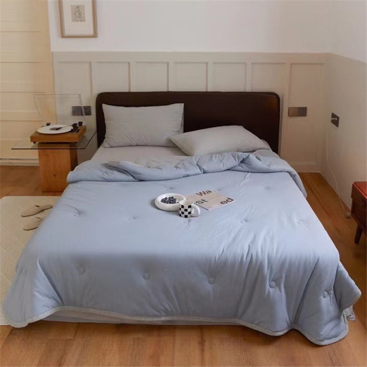 Light reversible quilted blanket made of microfiber with soft decorative stitching