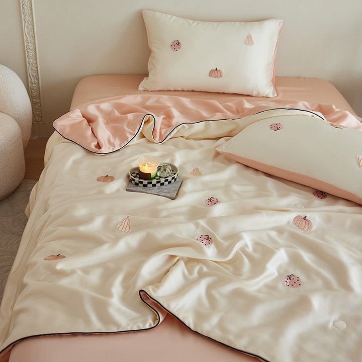 Luxurious satin bed linen set with embroidered Christmas tree motifs and contrasting piping