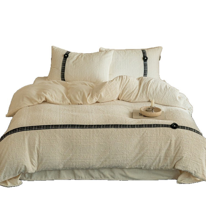Quilted bedding set with decorative contrast ribbon and button closure