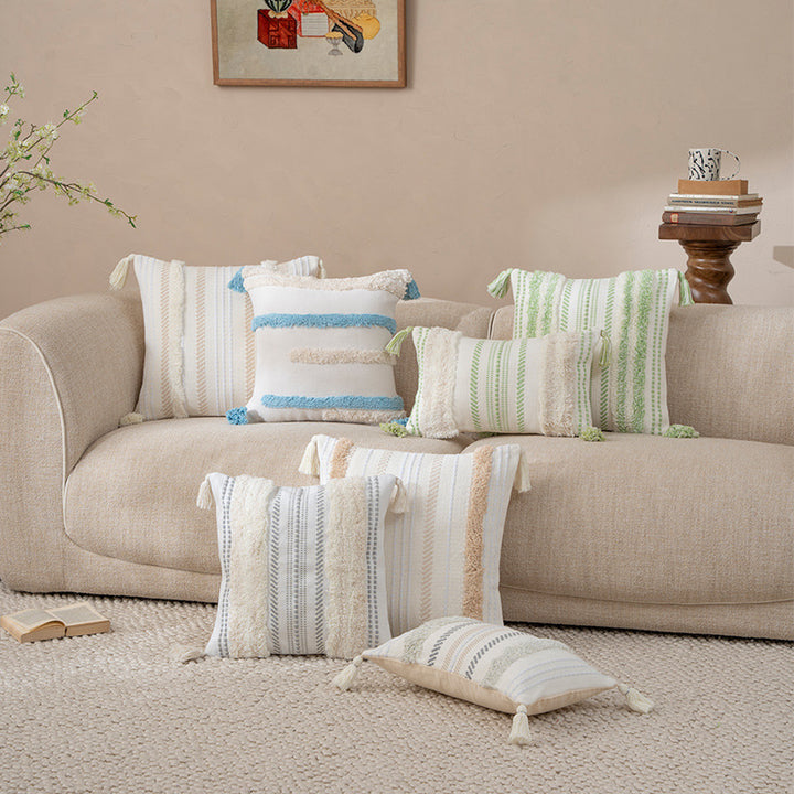 Square decorative cushion with boucle stripes, woven texture, and corner tassels