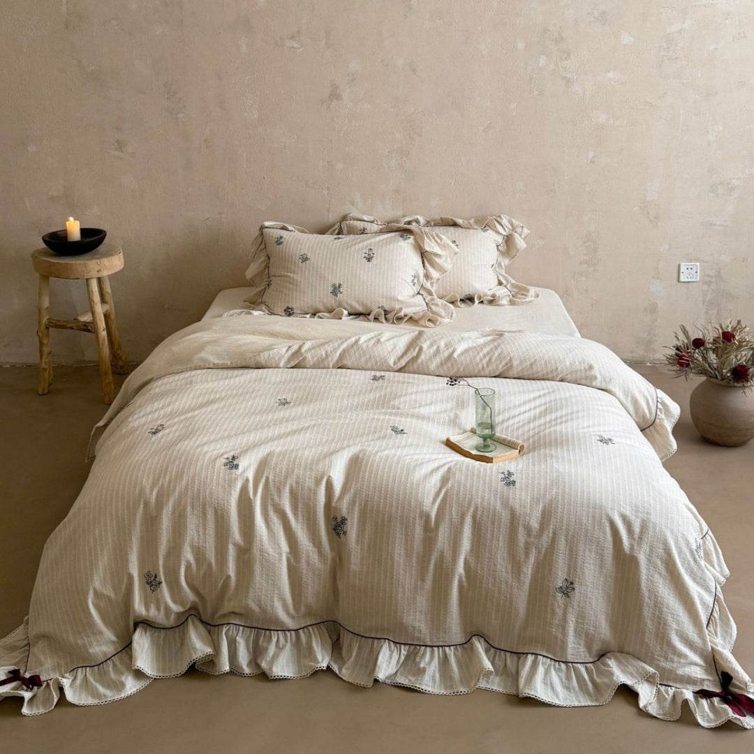 Vintage-look bedding set with ruffle, fine striped texture and subtle floral embroidery