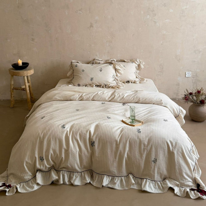 Vintage-look bedding set with ruffle, fine striped texture and subtle floral embroidery