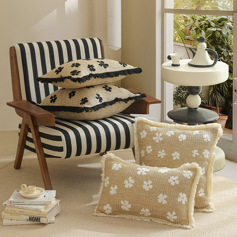 Rectangular woven decorative pillow with contrasting flower tufting and fringe trim