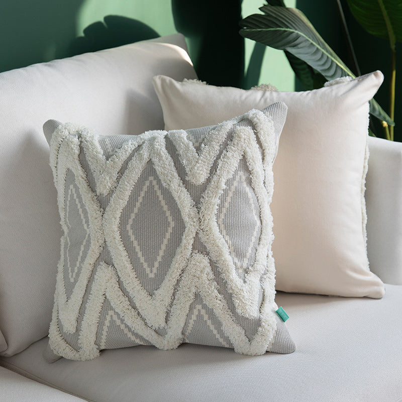 Decorative cushion cover with hand-tufted diamond relief and soft bouclé application
