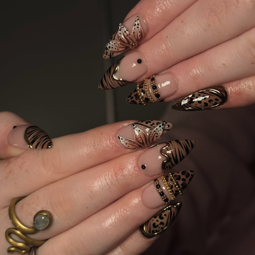 Artful stiletto nail with floral accents and gold embellishments Stornfield