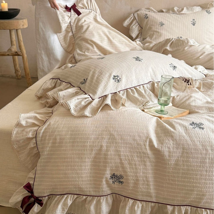 Vintage-look bedding set with ruffle, fine striped texture and subtle floral embroidery