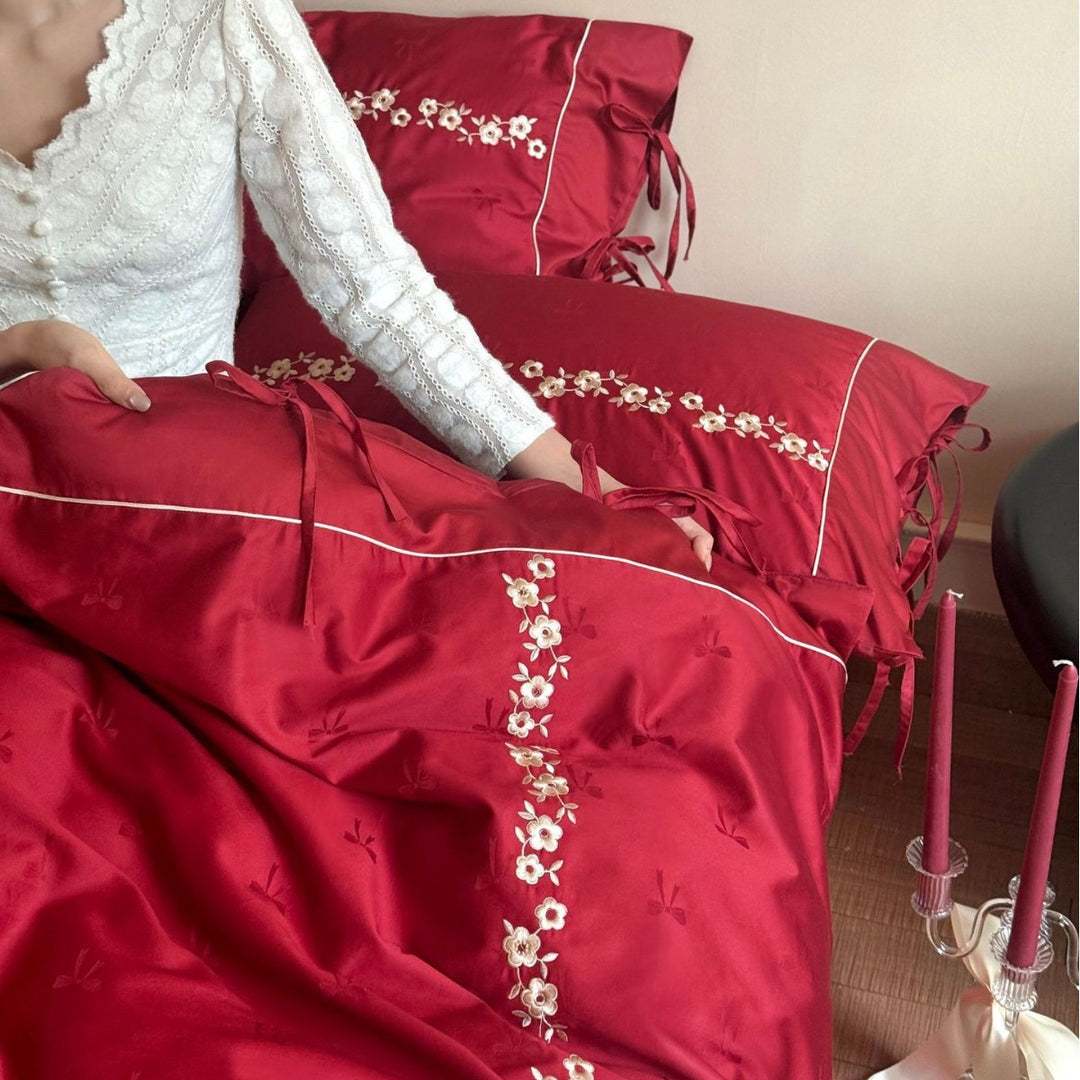 Bedding set made of cotton satin with floral border embroidery, decorative bows and pillow ensemble