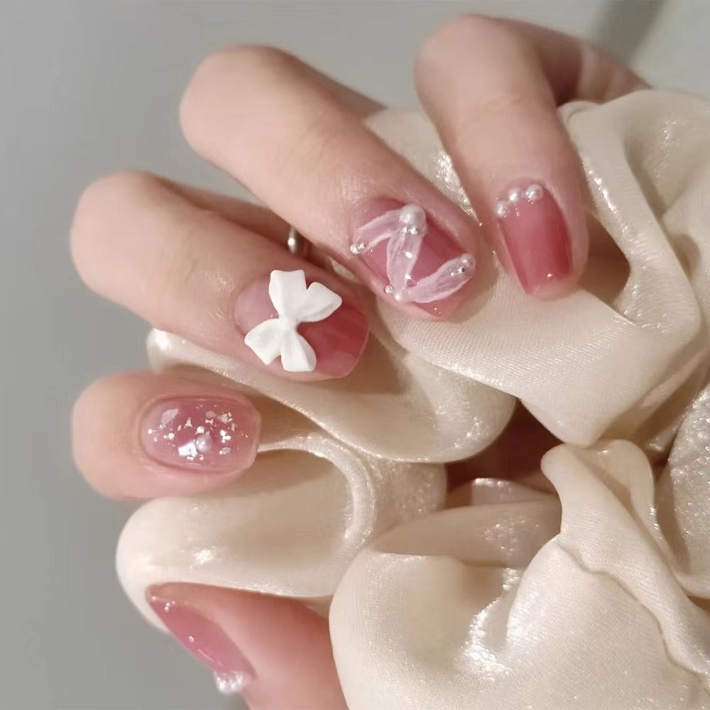 Glamorous nail art with pearl and bow accents Stornfield