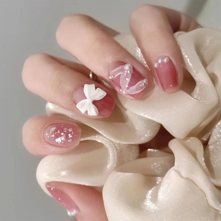 Glamorous nail art with pearl and bow accents Stornfield