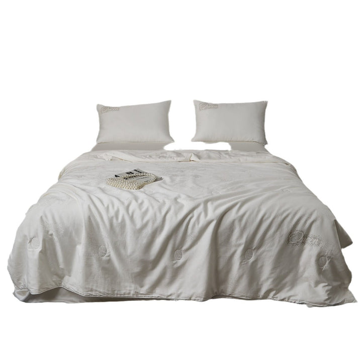 Quilted comfort duvet with fine jacquard structure and decorative button quilting