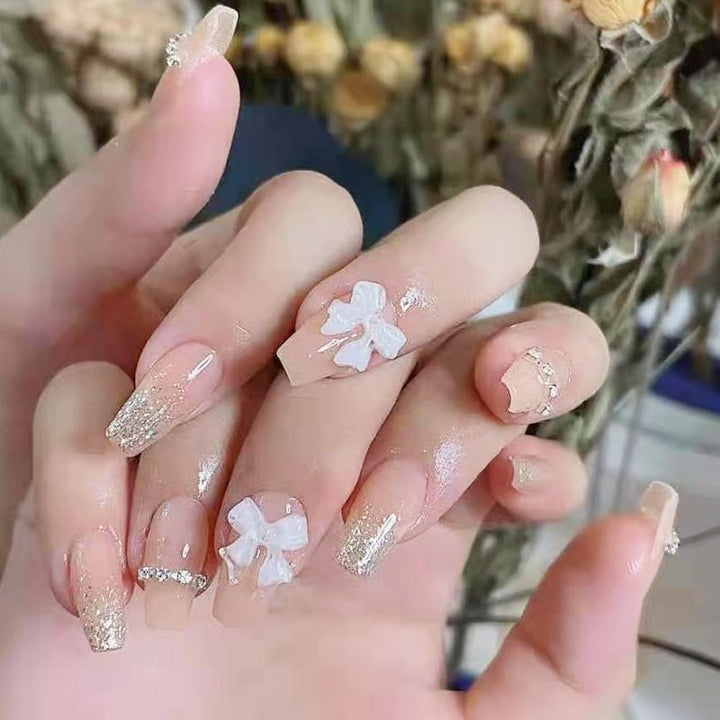 Artificial nails with elegant bow accents and pearl decorations Stornfield