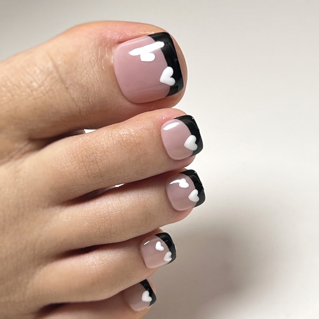 Artistic toenail design with heart motifs and modern black-and-white design Stornfield