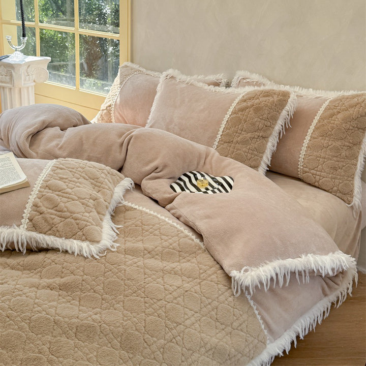 Quilted bedding with fringes and decorative pillows