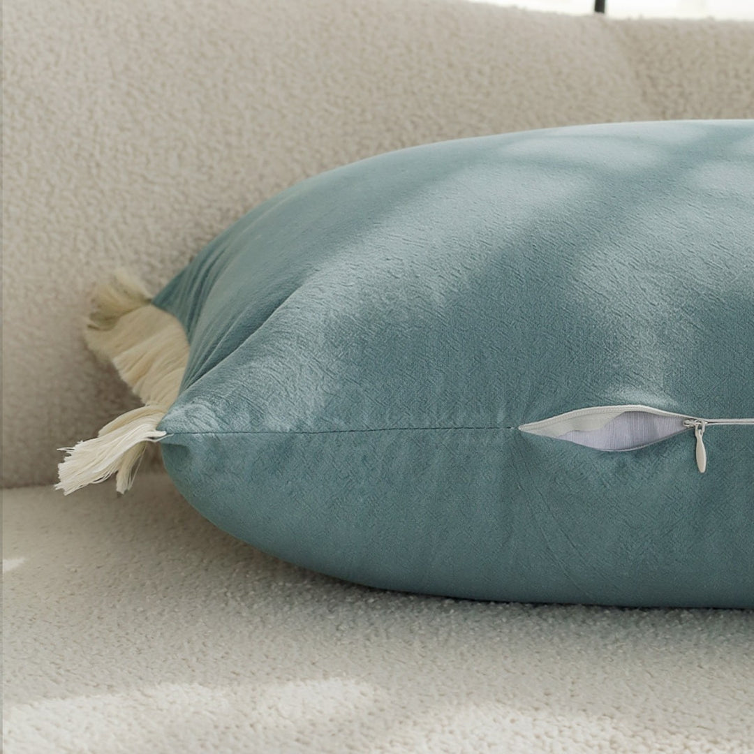 elongated decorative cushion with fringes and velvety surface