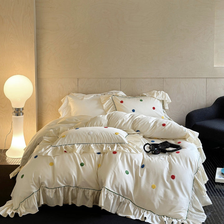 Playful bedding set with frill, colorful flock applications, and fine piping