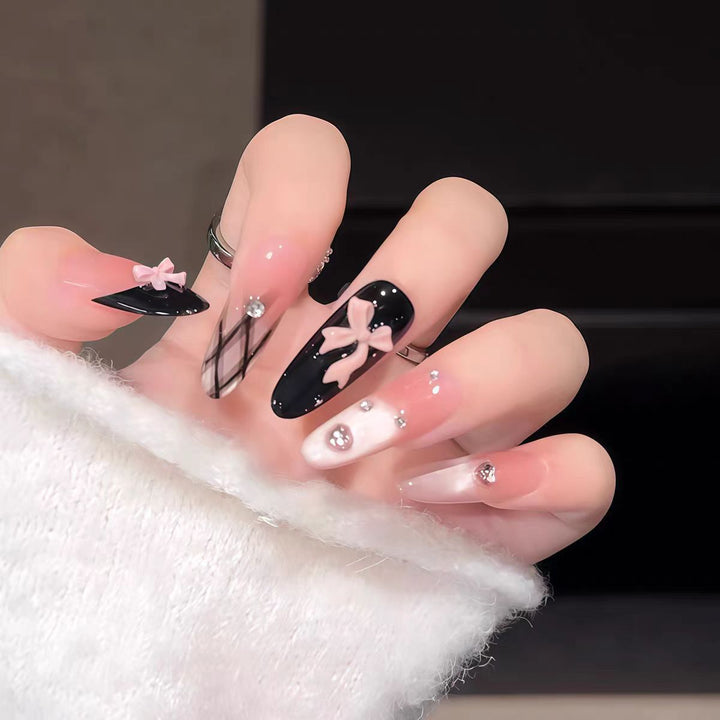 Artificial nails with playful bow and glitter accents Stornfield