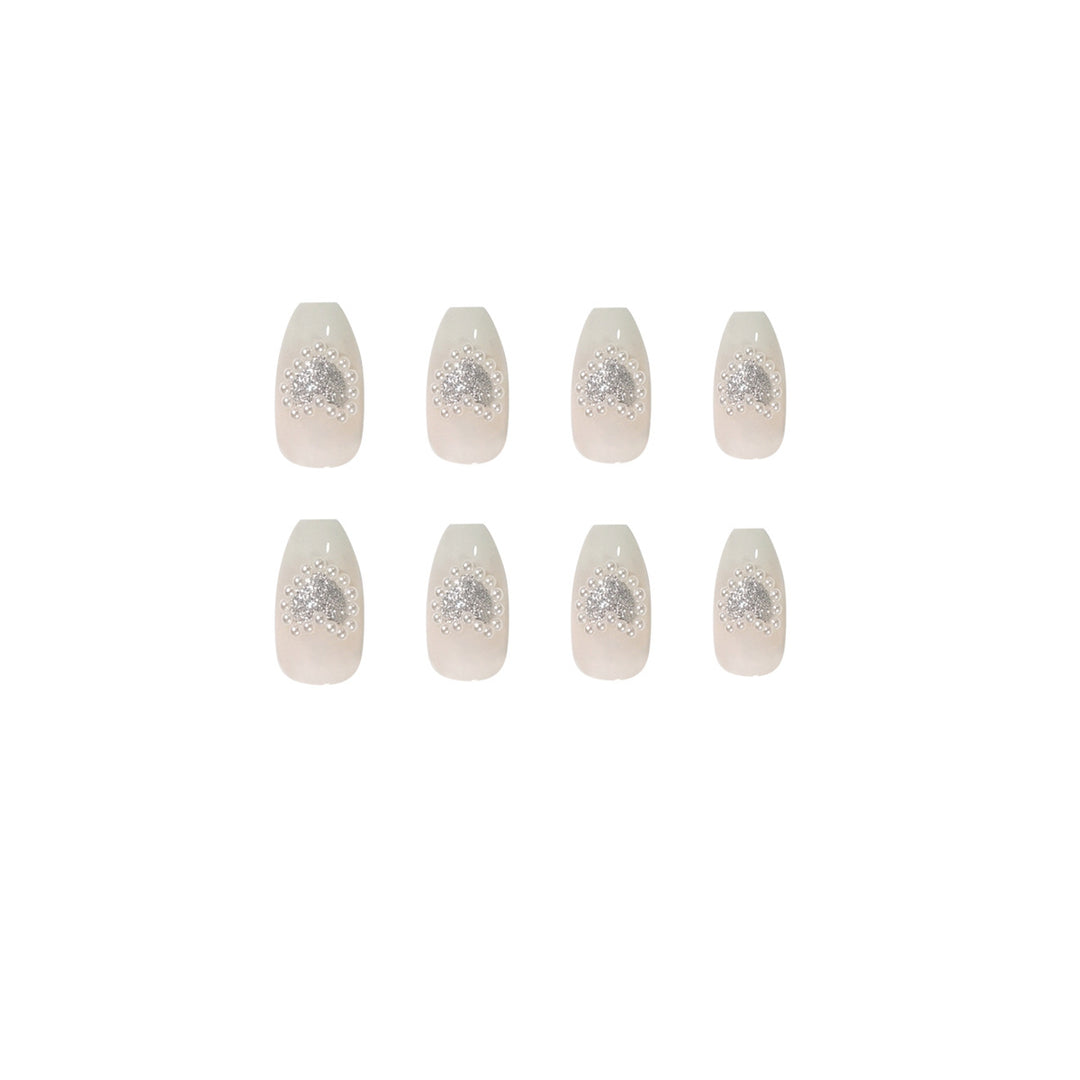 Artificial nail art with heart and rhinestone decorations Stornfield