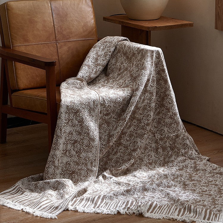Large cozy living blanket made of cotton blend fabric with geometric jacquard pattern and fringed hem