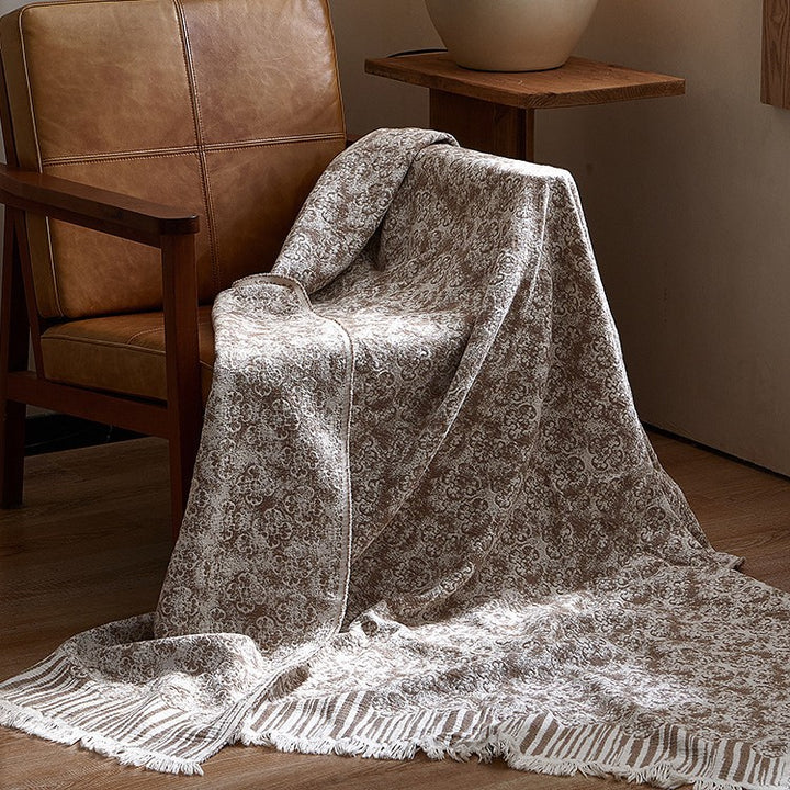 Large cozy living blanket made of cotton blend fabric with geometric jacquard pattern and fringed hem
