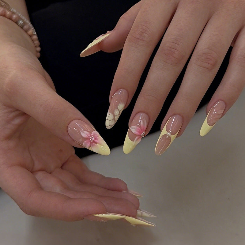 Acrylic nail set with elegant floral pattern and shimmering accents Stornfield