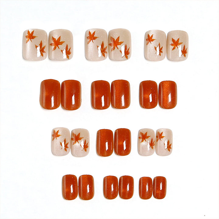 Artificial nails with glamorous ombre design and autumn leaf applications Stornfield