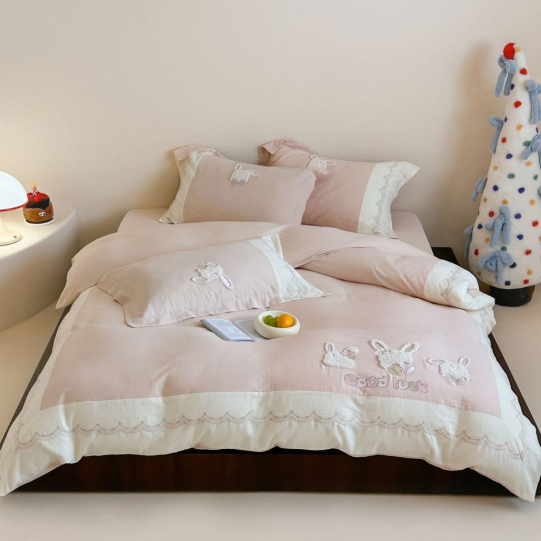Embroidered cotton satin bedding set with appliquéd rabbit designs and decorative border