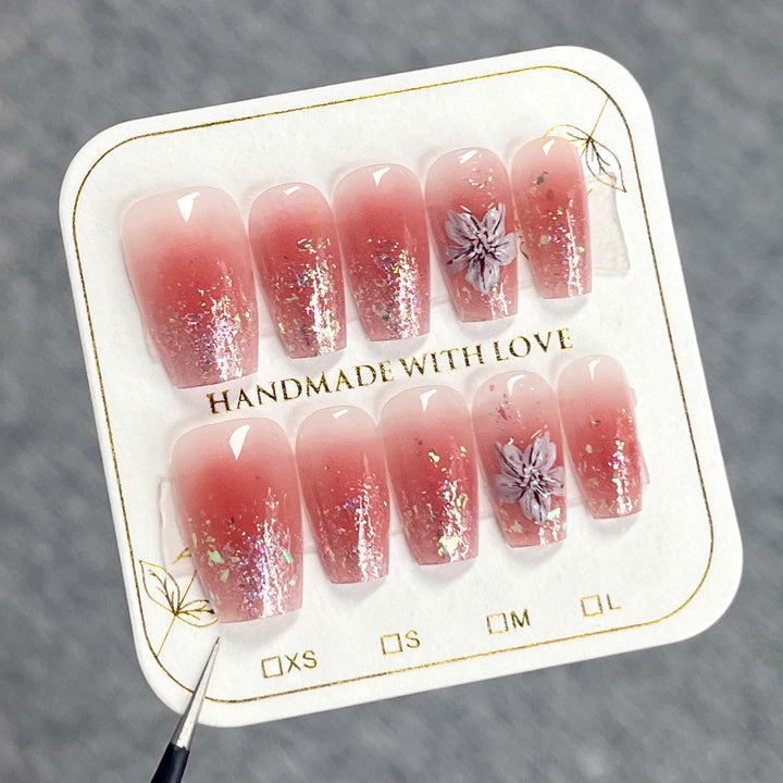 Artificial nail extensions with floral design and glitter accents Stornfield