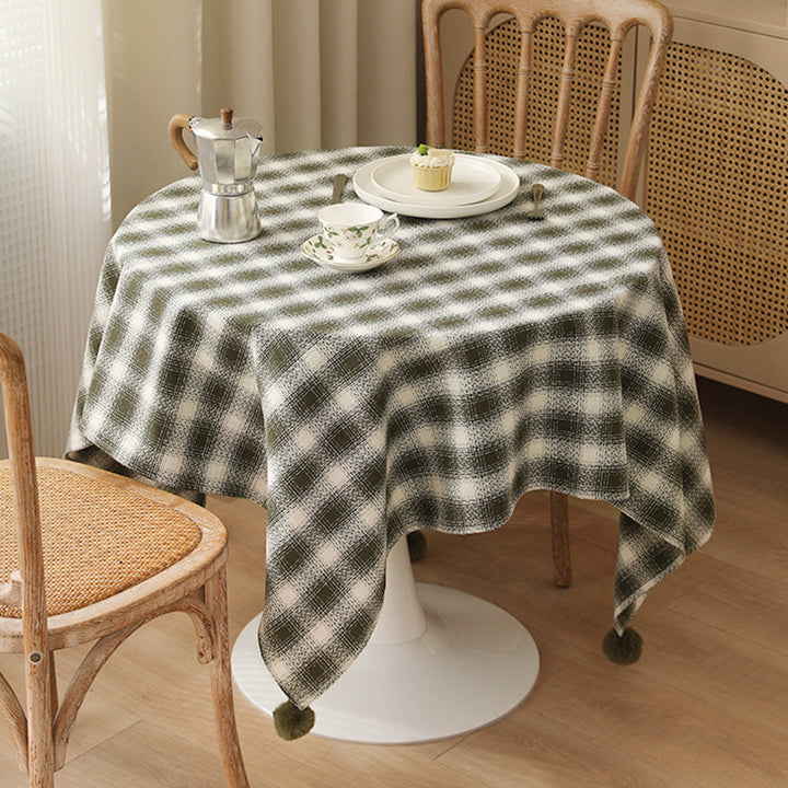 Rectangular checked tablecloth made of cotton blend with pom-pom corners