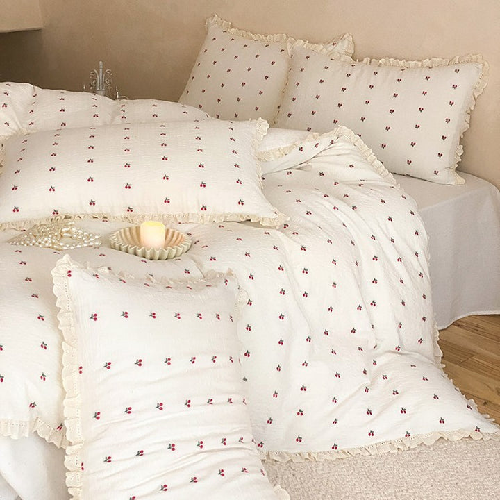 Quilted bedding set made of cotton muslin with delicate cherry print and ruffle edge