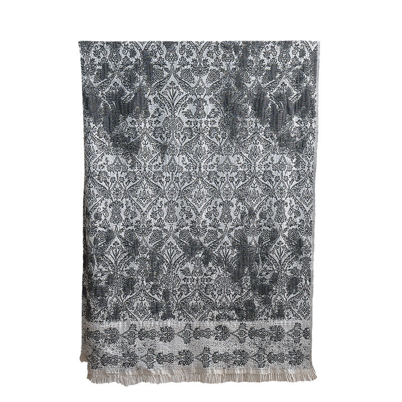 Large cozy living blanket made of cotton blend fabric with geometric jacquard pattern and fringed hem