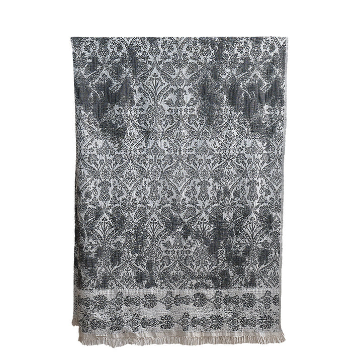 Large cozy living blanket made of cotton blend fabric with geometric jacquard pattern and fringed hem