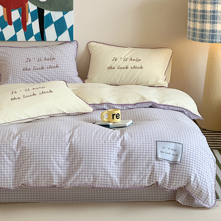 Striped cotton bedding set with subtle slogan appliqués and decorative piping