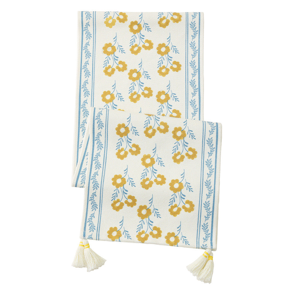 Hand-woven cotton table runner in country house style with delicate floral motifs and tassels