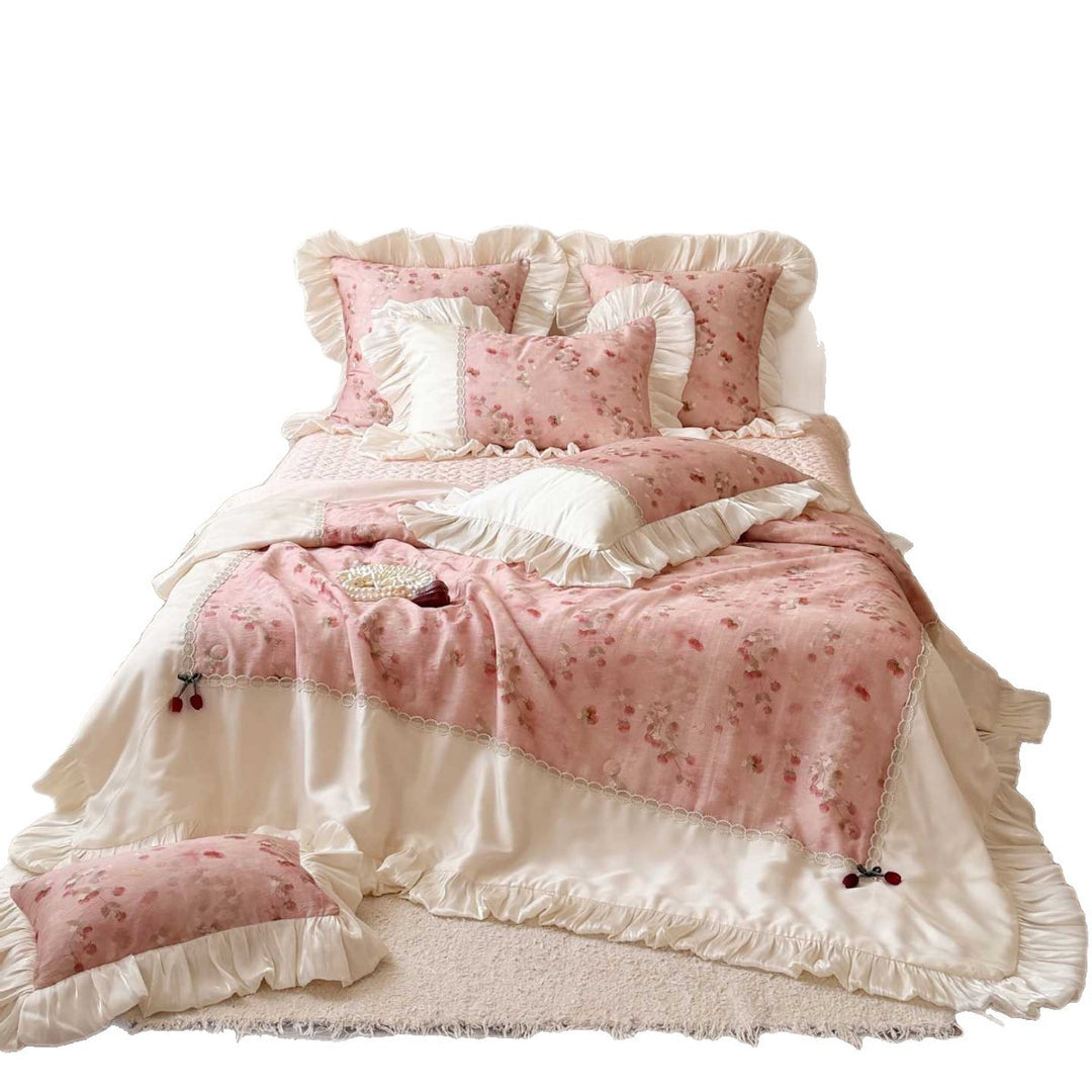 Romantic bedding set with ruffles, quilted bedspread, and decorative pillowcases