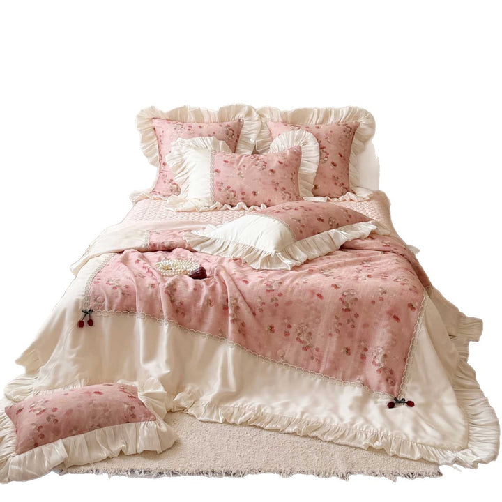 Romantic bedding set with ruffles, quilted bedspread, and decorative pillowcases