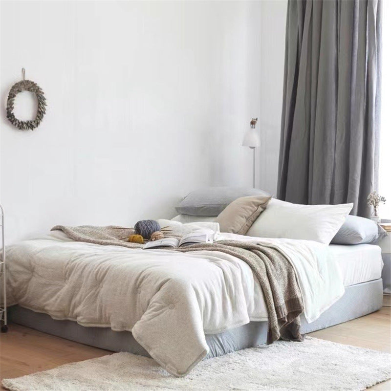 Light reversible quilted blanket made of microfiber with soft decorative stitching