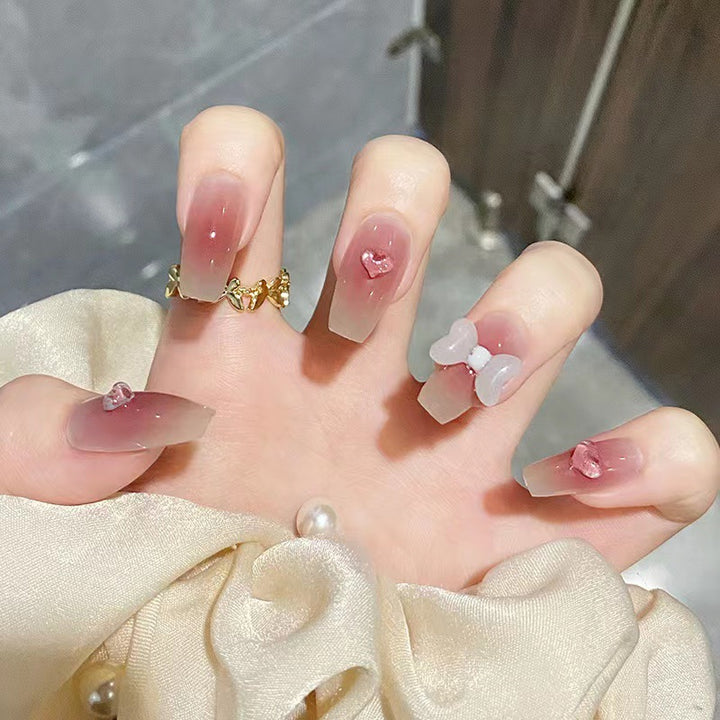 Artful acrylic nails with heart and bow design Stornfield
