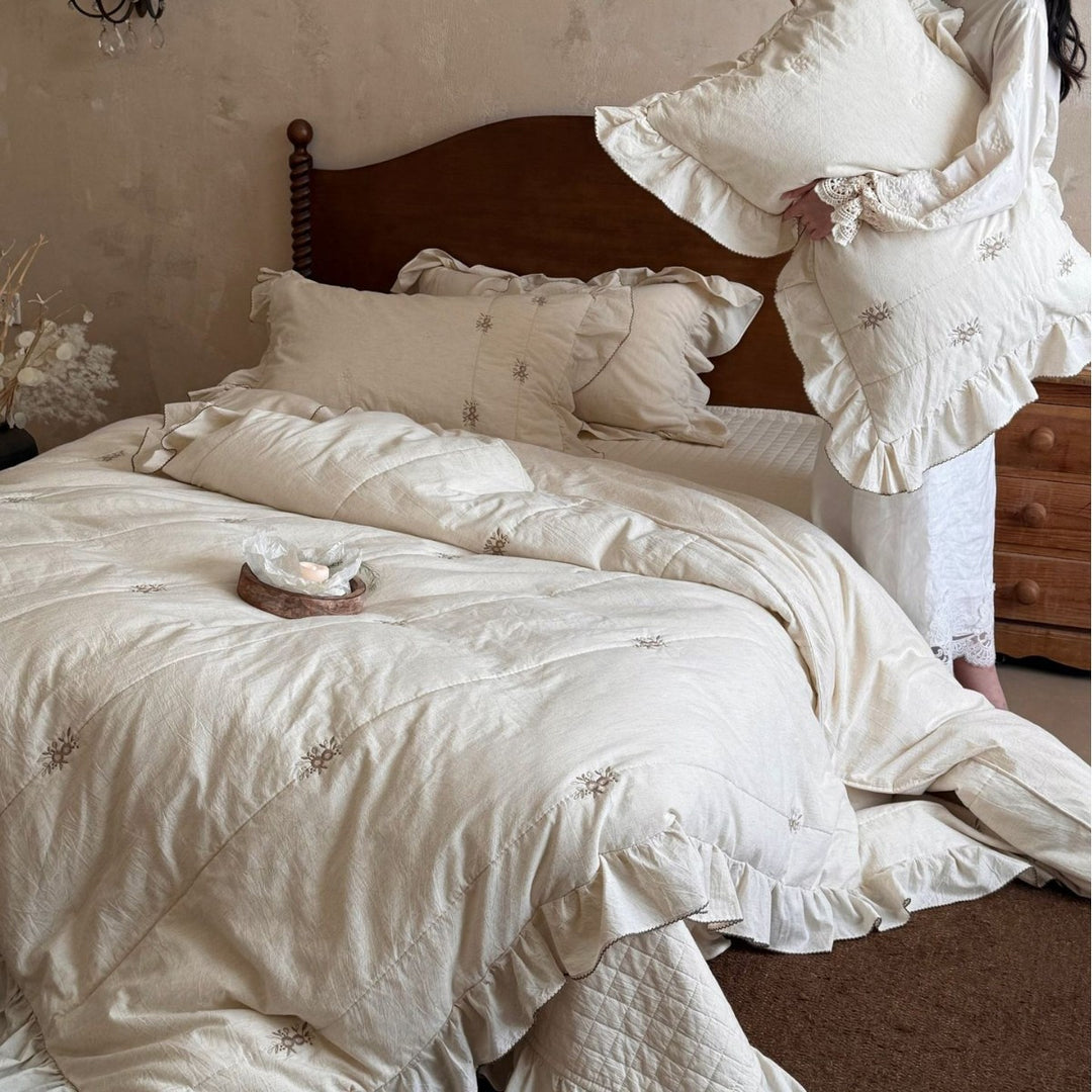 Bedding set in vintage look with ruffle, fine floral embroidery and quilted blanket