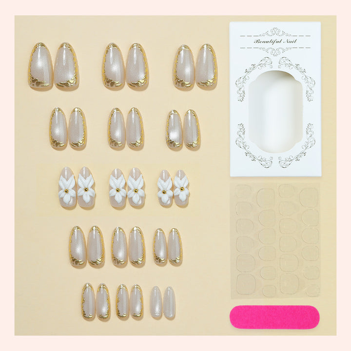 Acrylic nail set with elegant gold embellishments and floral accent Stornfield