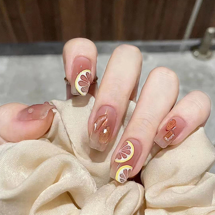Artificial nail set with cheerful citrus motifs and elegant designs Stornfield