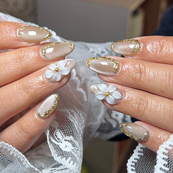 Acrylic nail set with elegant gold embellishments and floral accent Stornfield