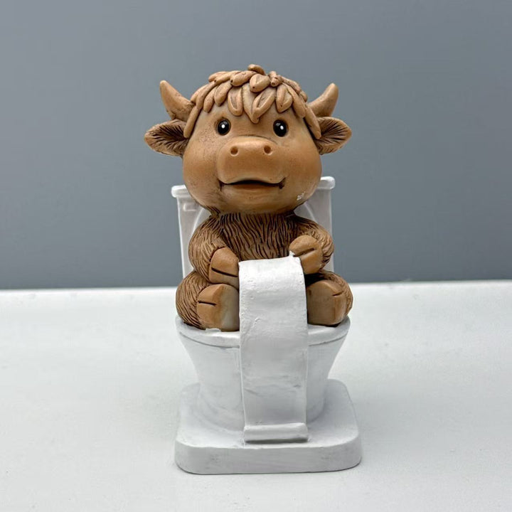 Funny decorative figure of a Highland cow on toilet Stornfield