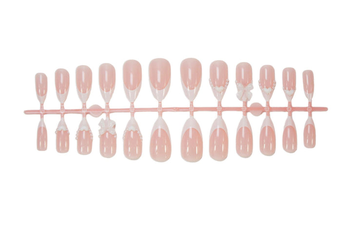 Artificial nail set with elegant tips and playful bow details Stornfield