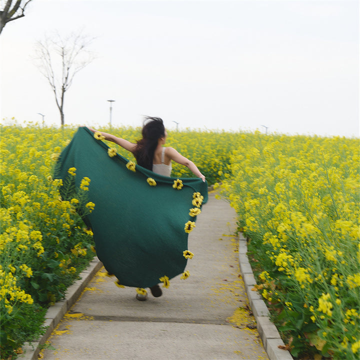 Crocheted throw blanket with 3D sunflower appliqués and chunky stitch structure