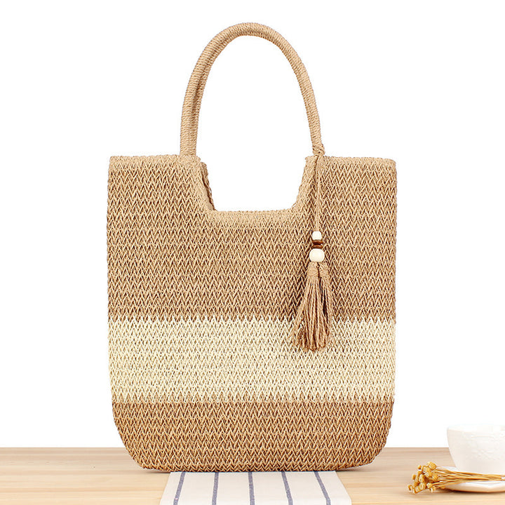 Fashionable beach tote bag made of woven natural material with fringed detail Stornfield