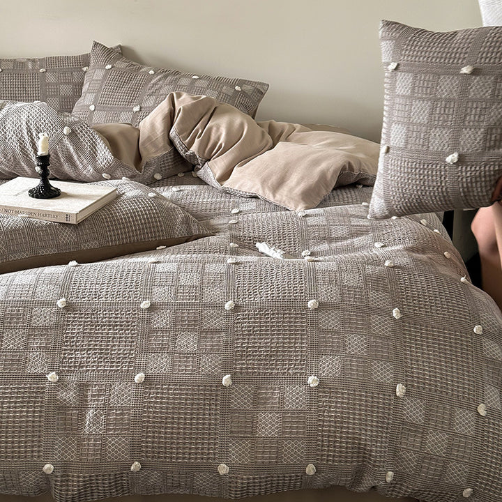 Luxurious cotton bedding set with textured waffle appearance and pompom details