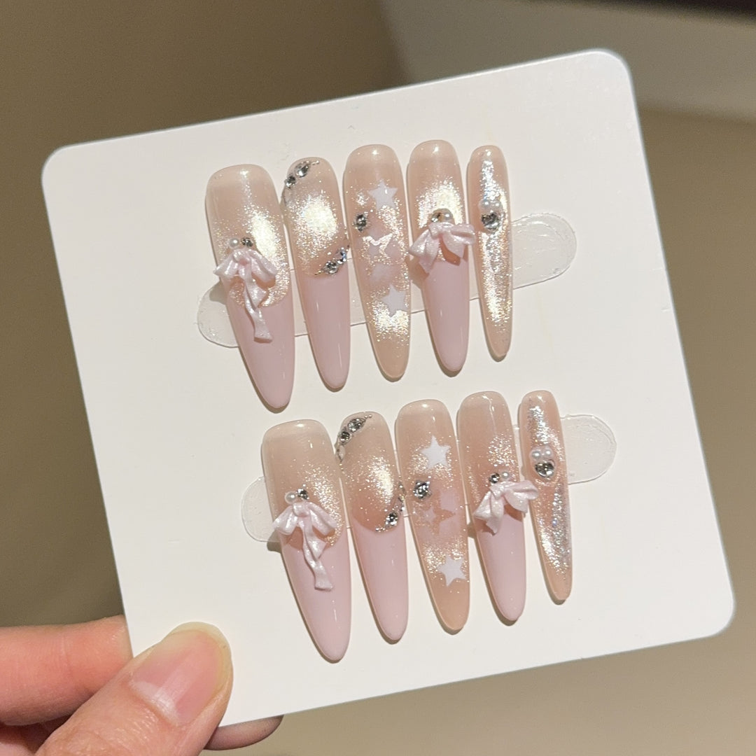 Artificial nail tips with glamorous glitter and bow details Stornfield