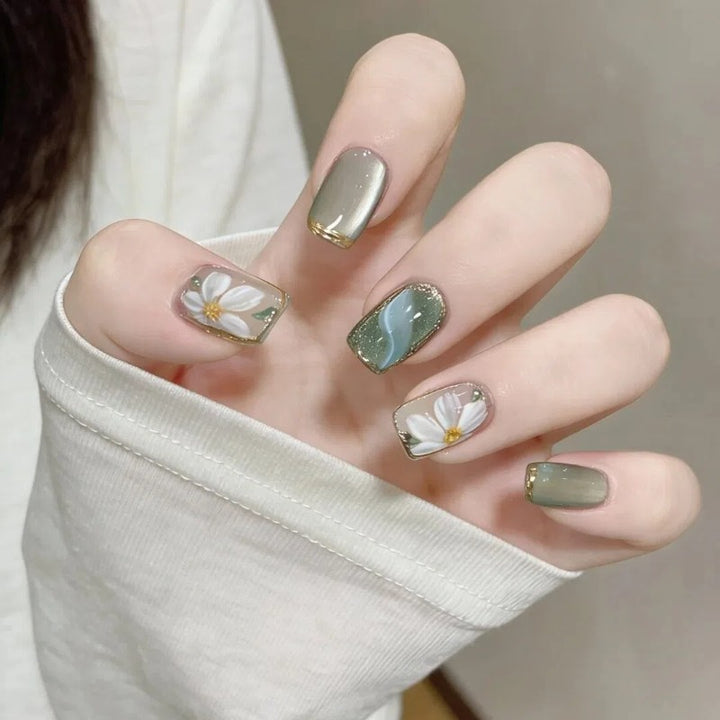Artificial nails with floral accents and glamorous gold trim Stornfield