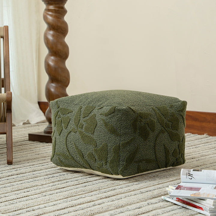 Square floor sitting pouf with textured bouclé surface and floral relief